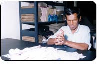 Photograph of a blind man making envelopes